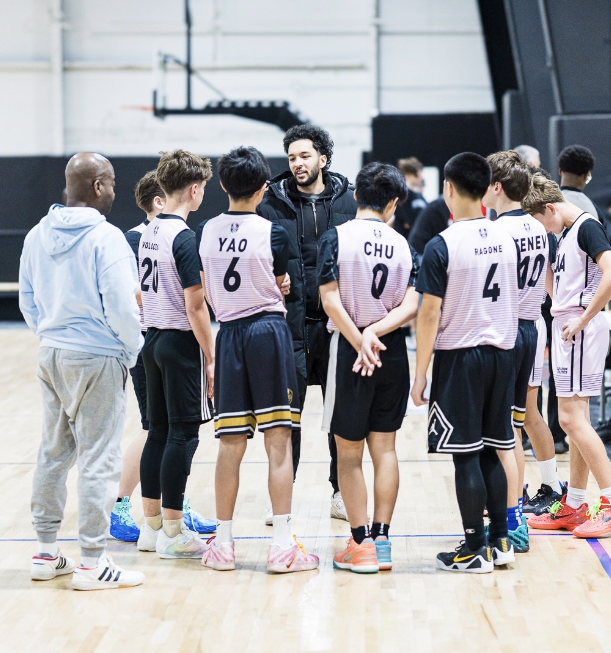 Seif Amer coaching a basketball team huddle